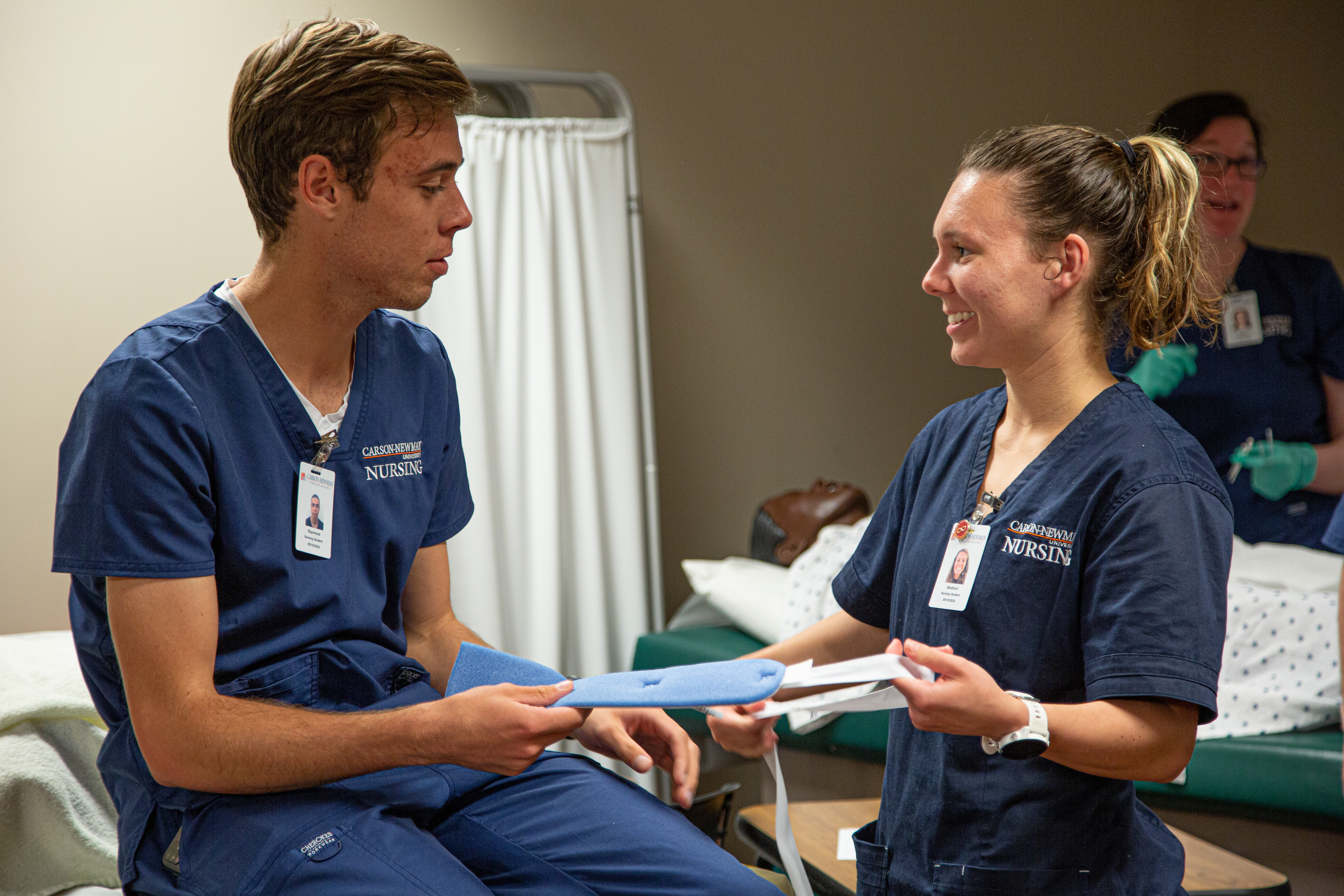 Two students, a man and woman, practice being a nurse and skills together in a Carson-Newman nursing lab