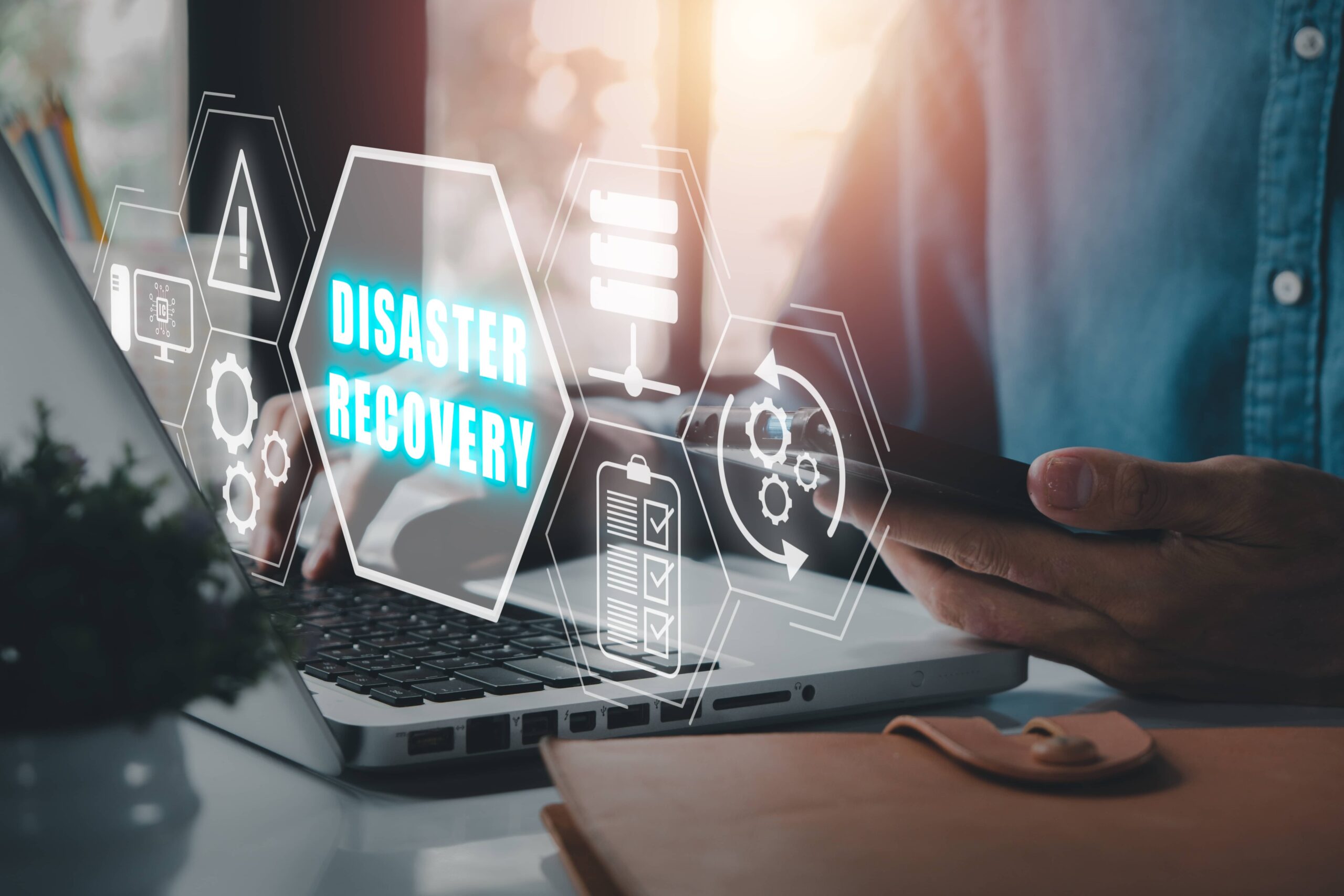 person on laptop with icon that says disaster recovery