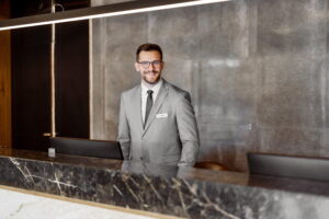 male hotel GM behind reception desk